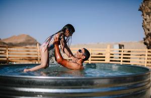 Ein Mann und eine Frau in einem Whirlpool in der Unterkunft Selina Ramon in Mitzpe Ramon