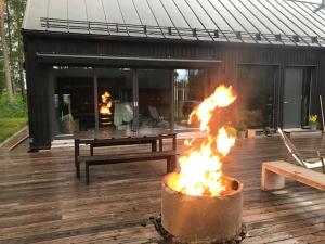 a fire pit on a wooden deck with a picnic table at Guesthouse Kärsämäki in Kärsämäki