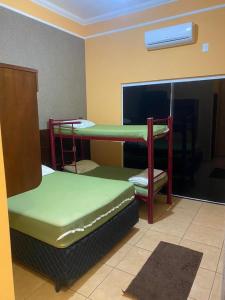 a room with two bunk beds and a window at Casa dos Carvalhos Rua do sabiá 25 coab 1 in Olímpia