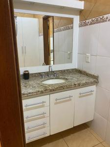 a bathroom with a sink and a mirror at Casa dos Carvalhos Rua do sabiá 25 coab 1 in Olímpia