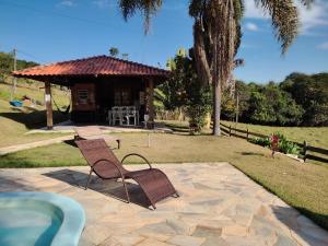 a patio with a chair and a table and a house at Terras de Bragança in Bragança Paulista