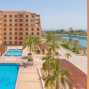 een luchtzicht op een hotel met een zwembad en palmbomen bij Baylasun Icon in King Abdullah Economic City