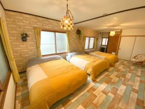 a bedroom with two beds and a brick wall at Shionoyu Onsen 汐の湯 モール温泉付き in Shiraoi