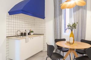 a kitchen with a table with chairs and a blue umbrella at Stylish loft in the city center in Trieste +12 photos