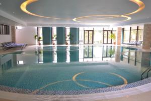 a large swimming pool in a building with a ceiling at Hotel Hart in Predeal