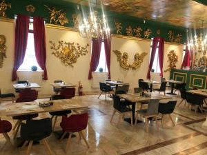 ein Esszimmer mit Tischen und Stühlen und einem Kronleuchter in der Unterkunft Hotel Kreta in Galaţi