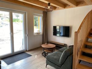 uma sala de estar com um sofá e uma mesa em Casa Blu Kärnten - One Holiday in Three Countries - Cold&Hottub, Sauna - Piste em Arnoldstein