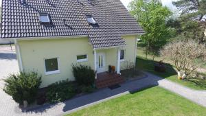 Casa blanca pequeña con porche y patio en Pokoje Sobie na Wyspie, en Gdansk