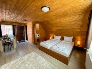 1 dormitorio con cama y techo de madera en Somogyi Vendégház, en Bancu
