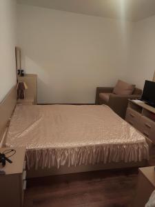 a small bedroom with a bed and a couch at Byala COZY APARTMENT in Byala