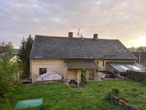 ein weißes Haus mit einem Zaun im Hof in der Unterkunft Penzionek U Františka in Mařenice