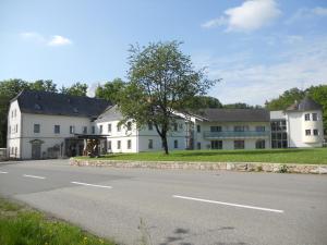 ein großes weißes Haus am Straßenrand in der Unterkunft Gasthof Sturmmühle in Saxen