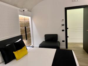 um quarto com uma cama com uma almofada amarela e uma cadeira em Toledo Boutique Rooms em Nápoles