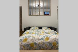 ein Schlafzimmer mit einem Bett mit einer bunten Bettdecke in der Unterkunft Appartement centre ville de Dieppe in Dieppe