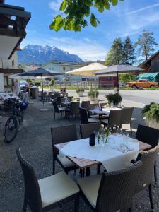 ein Restaurant im Freien mit Tischen, Stühlen und Sonnenschirmen in der Unterkunft Landgasthof Rössle ** Superior in Ruggell