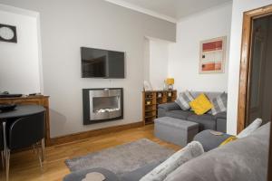 a living room with a couch and a fireplace at Beach Walk Apartment in Broughty Ferry