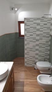 een badkamer met 2 wastafels, een toilet en een douche bij Donna Caterì in Termini