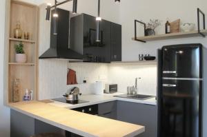 aella apartments في نيكيتي: مطبخ مع ثلاجة سوداء ومغسلة