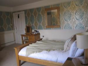 a bed in a room with a white bedspread at Yeo Dale Hotel in Barnstaple