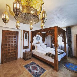 a bedroom with a canopy bed and a chandelier at TAJ Royal APARTMENT in Bucharest