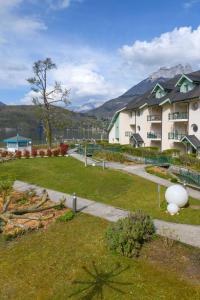 un parque con un edificio y un césped con un edificio en Logement avec terrasse sur lac, tout confort, dans résidence avec PLAGE et PONTON PRIVEE en Duingt