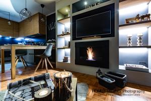 a living room with a fireplace and a tv at Hostdomus - Il Cerbiatto Apartment in Sestriere