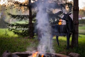 a statue of a deer standing next to a fire at Rouna Family Home in Ainja