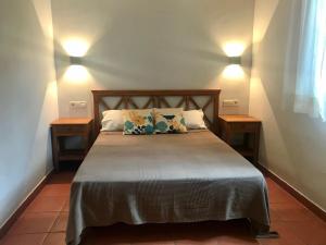 a bedroom with a large bed with two night stands at Hospedería Rural Aldeaduero in Saucelle
