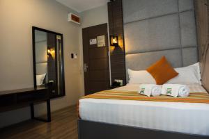 een slaapkamer met een bed met twee handdoeken erop bij Dy Viajero Transient Hotel in Naga
