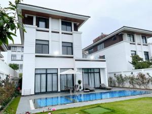 une maison blanche avec une piscine devant dans l'établissement FLC Villa Hạ Long 4 Phòng Ngủ, à Hạ Long 16 autres photos