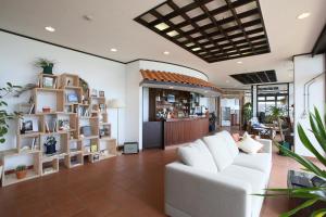 een woonkamer met een witte bank en een bar bij Haruhoo Resort ISHIGAKI in Ishigaki Island