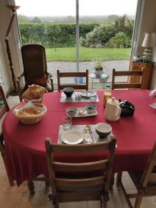 einen Esstisch mit einem roten Tisch und Stühlen in der Unterkunft Chambre d'hôtes de la Galie in Sainte-Marie-du-Mont