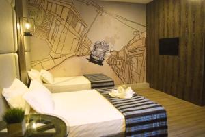 Pokój z dwoma łóżkami i rysunkiem na ścianie w obiekcie Dy Viajero Transient Hotel w mieście Naga