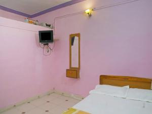 una camera con letto, specchio e TV di MM Cottage Near Mandir Road ad Alibaug