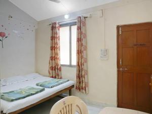 una piccola camera con letto e finestra di MM Cottage Near Mandir Road ad Alibaug
