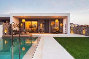 une maison avec une piscine et une arrière-cour dans l'établissement Nagia Luxury Family Villas, à Analipsi
