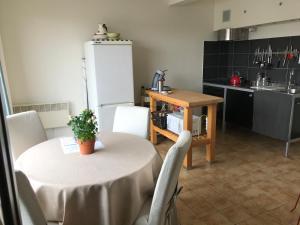 une cuisine avec une table et une cuisine avec une table et des chaises dans l'établissement Residentie Denise, au Coq