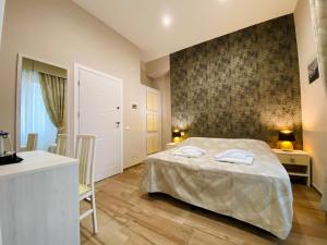ein Schlafzimmer mit einem Bett und einer Wand in der Unterkunft Hotelier 51 in Rom