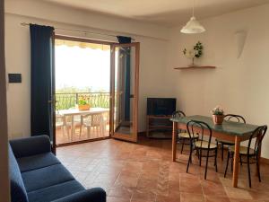 sala de estar con mesa y sillas y balcón en Villa Stefania, en Marina di Camerota