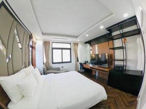 a bedroom with a large white bed and a desk at FLC Villa Hạ Long 5 Phòng Ngủ in Ha Long +11 photos