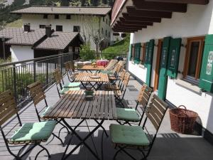 a patio with tables and chairs on a balcony at Chalet Sonnblick in Stuben am Arlberg