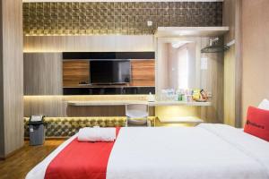 um quarto de hotel com uma cama e uma televisão em RedDoorz Plus @ Simpang USU Medan em Medan