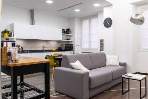 a living room with a couch and a kitchen at LargoDoria - ViaArchivolto, box auto privato incluso in Albenga