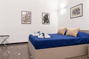 Un dormitorio con una cama azul con toallas. en LargoDoria - ViaArchivolto, box auto privato incluso, en Albenga