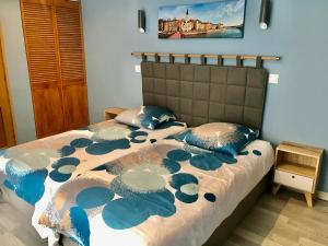 a bed with a blue and white comforter and pillows at Maison d'hôtes Côté Saône in Lyon