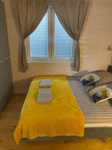 メヘリンキにあるDomki Mechelinkiのベッドルーム1室(大型ベッド1台、黄色い毛布付)