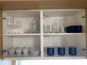 メヘリンキにあるDomki Mechelinkiのグラスと皿、ガラス製品が入った戸棚