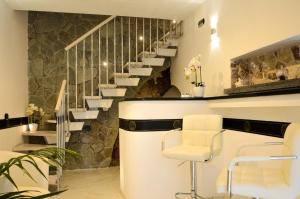 a salon with a white chair and stairs at Il Casanova in Tropea