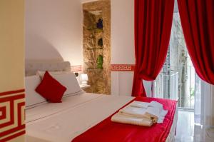 a bedroom with red curtains and a bed with towels on it at Il Casanova in Tropea