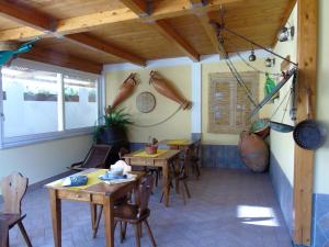 un restaurante con mesas de madera y sillas en una habitación en La Cantina dello Sgatto, en Procida